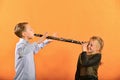 The boy plays the clarinet in the girlÃ¢â¬â¢s ear, the outraged girl waves her arms